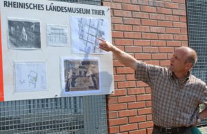 Dr. Joachim Hupe, wissenschaftlicher Leiter der Grabungen, erklärt am Lageplan den genauen Standort.