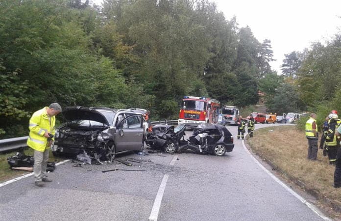 Symbolbild. Horrorcrash auf einer Landstraße. Beamte sichern Spuren und im Hintergrund ist die Feuerwehr zu sehen. Schwerste Verletzungen scheint es gegeben zu haben.