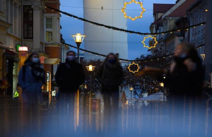 Passanten gehen durch eine festlich dekorierte Fuflg‰ngerzone