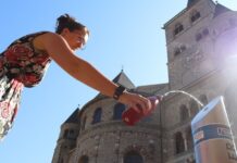 Trier: Erfrischung auf Knopfdruck – Trinkwasserbrunnen wieder in Betrieb Eine frau am trinkwasserspender vor dem Trierer Dom