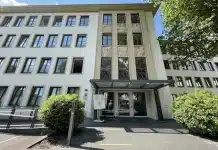 Geisterfahrer-Drama auf der A60: Warum der Prozess gegen den US-Soldaten in Trier startet Eingang des Landgerichts Trier mit Glasdach, umgeben von Fenstern und Büschen bei Tageslicht.