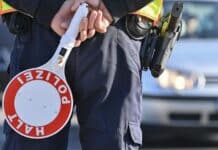 Trier: Polizei kündigt Kontrollen in der Bernhardstraße an Ein Polizeibeamter hält eine Winkerkelle in den Händen