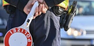 Trier: Polizei kündigt Kontrollen in der Bernhardstraße an Ein Polizeibeamter hält eine Winkerkelle in den Händen