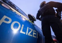 Unbekannte stehlen 3.580 Liter Heizöl aus Keller Polizist vor einem Polizeiwagen.