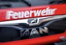 ++ Großbrand in Recyclingfirma in der Eifel — starke Rauchentwicklung ++ Der Schriftzug Feuerwehr steht auf einem Einsatzfahrzeug.