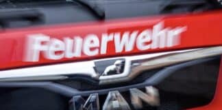 ++ Großbrand in Recyclingfirma in der Eifel — starke Rauchentwicklung ++ Der Schriftzug Feuerwehr steht auf einem Einsatzfahrzeug.