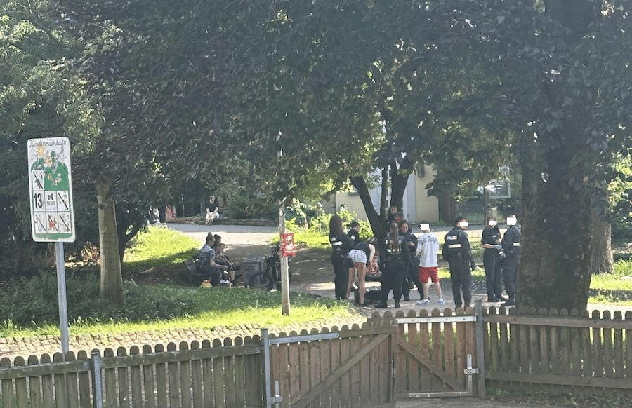 Polizeibeamte kontrollieren Personen im Rautenstrauchpark