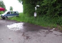 Eifersucht, Fotos, tödliche Schüsse! Mordprozess gegen 35-Jährigen startet vor dem Landgericht Trier Polizeibus am Waldrand, Spurensicherung auf Parkplatz mit Sicht auf Hinweisschilder, feuchter Asphalt nach Reinigung.