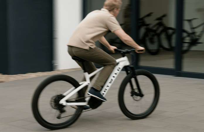 Unscharfes Symbolbild eines Mannes von hinten auf einem weißen Rotwild-E-Bike in Bewegung – gesuchter Fahrraddieb auf der Flucht.