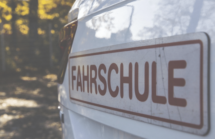 Weißes Fahrschulfahrzeug mit „Fahrschule“-Schild – Symbolbild für Ermittlungen im Führerscheinbetrugsfall in Deutschland
