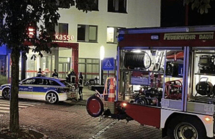 Vor der Filiale der Sparkasse in Daun stehen ein Polizeiwagen sowie ein Einsatzfahrzeug der Feuerwehr Daun