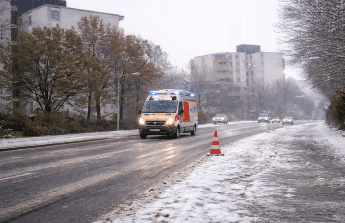 Winterliche Stadtstraße mit nasser Fahrbahn und Gehweg bei grauem Wetter in Trier – Symbolbild für Verkehrsunfall bei Schnee und Glätte.