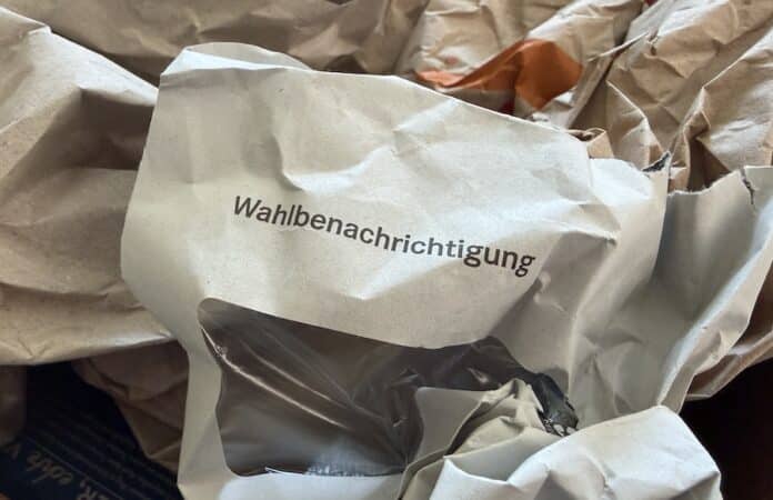 Der Briefumschlag einer Wahlbenachrichtigung liegt im Papiermüll