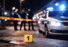 Messerstiche in gemeinsamer Wohnung: 52-Jährige stirbt – Ehemann unter Verdacht! Polizeiauto mit Blaulicht und abgesperrter Tatortbereich bei Nacht, unscharfe Einsatzkräfte im Hintergrund als Symbolbild für eine Messerattacke