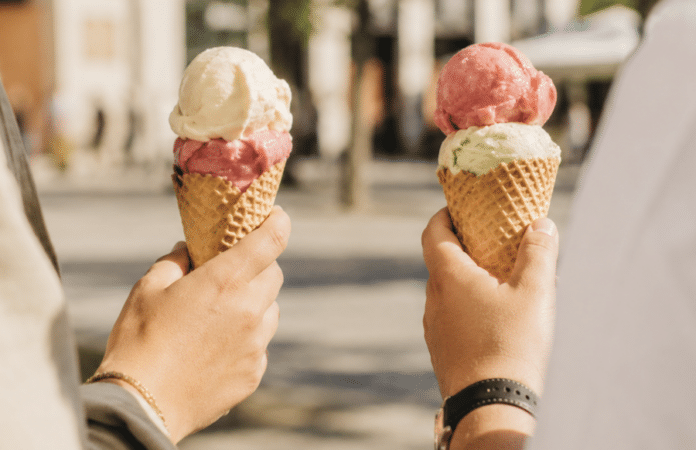 Zwei Personen essen Eis in der Waffel in sommerlicher Innenstadt-Atmosphäre – Symbolbild zum Falstaff-Sieg des Eiscafés Rigoni aus Trier als beliebteste Eisdiele in Rheinland-Pfalz 2026.